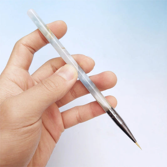 One hand holding a paintbrush