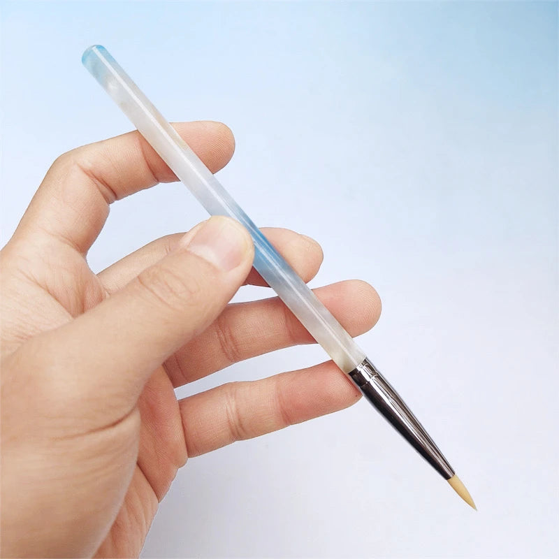 One hand holding a paintbrush